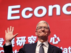 Apple CEO Tim Cook waves as he arrives for the Economic Summit held for the China Development Forum in Beijing, China, Saturday, March 23, 2019. Cook says he's "extremely bullish" about the global economy based on the amount of innovation being carried out, and he's urging China to continue to "open up."