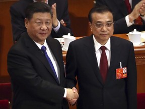 FILE- In this March 18, 2018, file photo, Chinese President Xi Jinping, left, shakes hands with Premier Li Keqiang after Li was re-elected as Premier during a plenary meeting of China's National People's Congress (NPC) at the Great Hall of the People in Beijing, Thousands of delegates from around China are gathering in Beijing for annual session of the country's rubber-stamp legislature and its advisory body, an event characterized more by the authoritarian ruling Communist Party leadership's desire to communicate its message than any actual discussion or passage of laws.