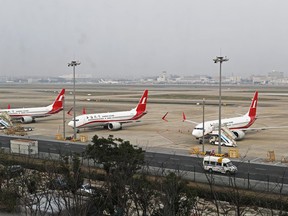 In this photo taken Monday, March 11, 2019, three Shanghai Airlines Boeing 737 Max 8 passenger planes are parked at the Hongqiao Airport in Shanghai, China. U.S. Aviation experts on Tuesday, March 12, 2019 joined the investigation into the crash of an Ethiopian Airlines jetliner that killed 157 people, as a growing number of airlines grounded the new Boeing plane involved in the crash. (Chinatopix via AP)