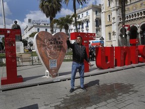 A Tunisian man takes selfie on a street in downtown Tunis, Tunisia, Thursday, March 28, 2019. Tunisia is cleaning up its boulevards and securing its borders for an Arab League summit that this country hopes raises its regional profile and economic prospects. Government ministers from the 22 Arab League states are holding preparatory meetings in Tunis all week for Sunday's summit.