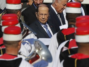 Lebanese President Michel Aoun, center, reviews the Tunisian musicians, upon his arrival at Tunis-Carthage international airport to attend the Arab Summit, in Tunis, Tunisia, Saturday, March 30, 2019.