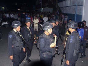 Police officers stand guard near the house of an Islamic militant in Sibologa, North Sumatra, Indonesia, Wednesday, March, 13, 2019. The wife and child of an arrested Islamic militant who was plotting attacks in the Indonesian capital have died in an explosion during a siege of their home in North Sumatra, the national police chief said Wednesday.(AP Photo)