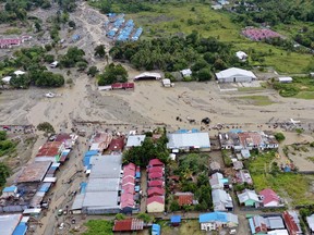 This aerial shot taken on Sunday, March 17, 2019 shows the area affected by flash floods in Sentani, Papua province, Indonesia. Flash floods and mudslides triggered by downpours tore through mountainside villages in Indonesia's easternmost province, killing dozens of people, disaster officials said.