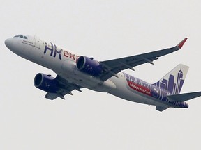 In this March 26, 2019 photo, a Hong Kong Express Airways passenger aircraft takes off from at the Hong Kong International Airport.  Cathay Pacific Airways is acquiring Hong Kong-based budget airline HK Express. Cathay said Wednesday, March 27, 2019, it will pay 4.93 billion Hong Kong dollars ($628 million) for HK Express. It said the acquisition will retain its identity as a separate brand and be operated as a low-cost carrier.