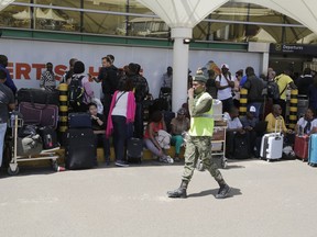 Stranded passengers wait for their flights out of JKIA airport in Nairobi, Kenya, Wednesday, March 6, 2019.  Some hundreds of air passengers were stranded Wednesday in Kenya because of a strike at Nairobi's international airport by the Kenya Aviation Workers Union.