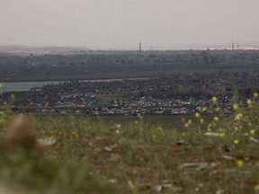 In this Sunday, March 17, 2019, photo, the Islamic State group's last pocket of territory in Baghouz, Syria, as seen from a distance. On Tuesday, a spokesman for U.S.-backed forces fighting IS in Syria says his fighters are in control of an encampment in the village of Baghouz where IS militants have been besieged for months.