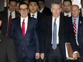 FILE - In this Feb. 15, 2019, file photo, U.S. Treasury Secretary Steven Mnuchin, left, and U.S. Trade Representative Robert Lighthizer walk together as they leave their hotel in Beijing. China says U.S. trade negotiators will arrive in Beijing late Thursday afternoon and start the new round talks with a working dinner.