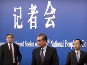 Chinese Foreign Minister Wang Yi, center, leaves after a press conference on the sidelines of the annual meeting of China's National People's Congress (NPC) in Beijing, Friday, March 8, 2019. The U.S.-North Korea summit in Vietnam last week was an "important step" toward denuclearization on the Korean peninsula, China's foreign minister said Friday.