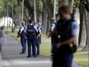 Police keep watch at a park across the road from a a mosque in central Christchurch, New Zealand, Friday, March 15, 2019.