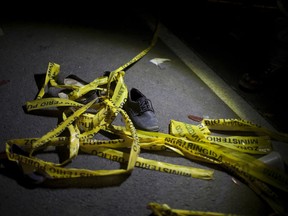 Yellow police tape and a shoe lay on the ground in the place where an accident occurred, in Nahuala, Guatemala, early Thursday, March 28, 2019. A large truck slammed into a crowd gathered on a dark highway in western Guatemala, killing over a dozen people and leaving bodies scattered on the roadway, firefighters said.