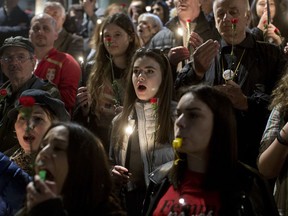 Protesters light candles as they gather in front of the state TV building in Belgrade, Serbia, Saturday, March 23, 2019. Thousands of people have rallied in Serbia against populist president Aleksandar Vucic after political tensions soared last weekend when protesters burst into the state TV building angry over the station's reporting that they view as biased.