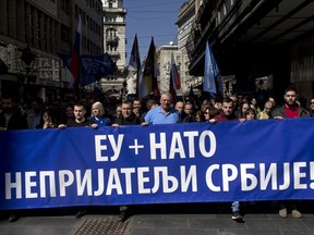 Vojislav Seselj, center, the leader of the ultranationalist Serbian Radical Party, and his supporters, march along a street during a protest in Belgrade, Serbia, Sunday, March 24, 2019. Members of the ultranationalist Serbian Radical Party gathered for a protest on Sunday in the Serbian capital to mark the 20th anniversary of the NATO led bombing campaign against Serbia in 1999. The banner reads 'EU + NATO, Enemies of Serbia!' in Serbian Cyrillic letters.