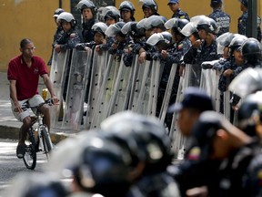 Police stand guard in anticipation of a march called by a coalition of opposition parties and civic groups who are petitioning lawmakers for a law of guarantees that will protect workers who have been victims of political retaliation and unjustified dismissals, in Caracas, Venezuela, Tuesday, March 19, 2019.