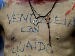 A supporter of Venezuela's self-proclaimed interim president Juan Guaido, with a message on his torso that reads in Spanish: "Venezuela with Guaido," attends an opposition rally a rally in Carrizal, Miranda State, Venezuela, Saturday, March 30, 2019. Guaido addressed the crowd while Maduro loyalists gathered for what was billed as an "anti-imperialist" rally in the capital. Such dueling demonstrations have become a pattern in past weeks as Venezuela's opposing factions vie for power in a country enduring economic turmoil and a humanitarian crisis.
