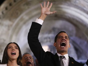 Accompanied by his wife Fabiana Rosales, Venezuela's self-proclaimed interim president Juan Guaido waves to supporters outside the Foreign Ministry in Buenos Aires, Argentina, Friday, March 1, 2019. Guaido is in tour of several South American capitals as part of a campaign to build international pressure on his rival Nicolas Maduro to quit.