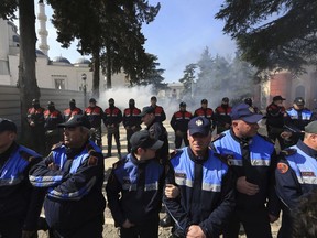 Police officers stand guard during an anti-government rally in Tirana, Albania, Thursday, March 21, 2019. Thousand opposition protesters have gathered in front of Albania's parliament building calling for the government's resignation and an early election. Rally is part of the center-right Democratic Party-led opposition's protests over the last month accusing the leftist Socialist Party government of Prime Minister Edi Rama of being corrupt and linked to organized crime.