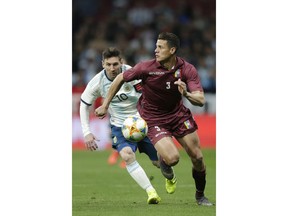 Argentina's Lionel Messi, left, fights for the ball with Venezuela's Yordan Osorio during an international friendly soccer match between Argentina and Venezuela at Wanda Metropolitano stadium in Madrid, Spain, Friday, March 22, 2019.