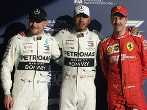 Mercedes drivers Lewis Hamilton of Britain, center, and Valtteri Bottas of Finland, left, pose with Ferrari driver Sebastian Vettel of Germany after qualifying for the Australian Grand Prix in Melbourne, Australia, Saturday, March 16, 2019. Hamilton qualified first, Bottas second and Vettel in third place on the grid for the first race of the year, Sunday.