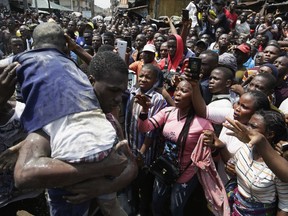 A child is rescued from the rubble of a collapsed building in Lagos, Nigeria, Wednesday, March 13, 2019. Rescue efforts are underway in Nigeria after a three-story school building collapsed while classes were in session, with scores of school children thought to be inside at the time.