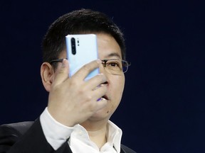Huawei CEO Richard Yu displays the new Huawei P30 smartphone during a presentation, in Paris, Tuesday, March 26, 2019.