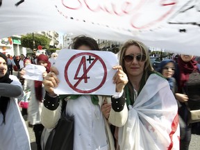 A teacher holds a placard during a protest in Algiers, Algeria, Wednesday, March 13, 2019. Algerian teachers gathered outside the central post office in the capital Algiers to protest President Abdelaziz Bouteflika's decision to delay next month's presidential election.