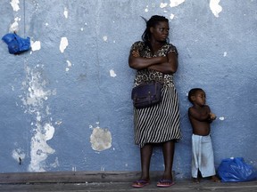 A woman and her child send against the wall at a displacement centre in Beira, Mozambique, Friday, March 22, 2019. A week after Cyclone Idai hit coastal Mozambique and swept across the country to Zimbabwe, its death, destruction and flooding continues to grow in southern Africa, making it one of the most destructive natural disasters in the region's recent history