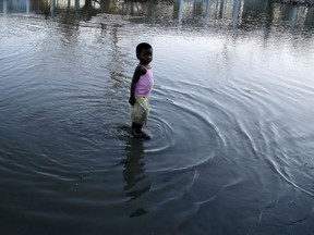 A young girl plays in the water outside a school in Beira, Mozambique, Monday, March 25, 2019. Cyclone Idai's death toll has risen above 750 in the three southern African countries hit 10 days ago by the storm, as workers rush to restore electricity, water and try to prevent outbreak of cholera.