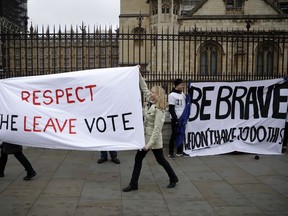 Pro-Brexit leave the European Union supporters, left, and anti-Brexit remain in the European Union supporters take part in a protest outside the Houses of Parliament in London, Tuesday, March 12, 2019. British Prime Minister Theresa May faced continued opposition to her European Union divorce deal Tuesday despite announcing what she described as "legally binding" changes in hopes of winning parliamentary support for the agreement.