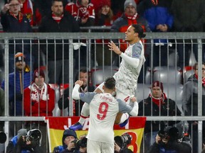 Liverpool defender Virgil Van Dijk, right, celebrates after scoring his side's second goal during the Champions League round of 16 second leg soccer match between Bayern Munich and Liverpool in Munich, Germany, Wednesday, March 13, 2019.