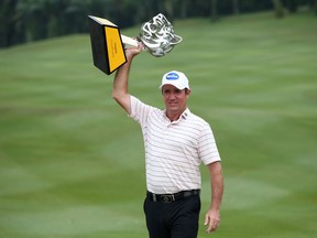 Scott Hend of Australia holds up his trophy after winning the Malaysia Golf Championship in Kuala Lumpur, Malaysia, Sunday, March 24, 2019.