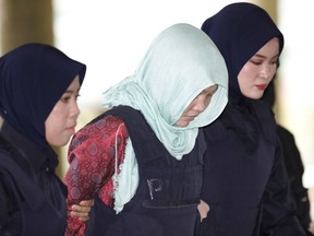 Vietnamese Doan Thi Huong, center, is escorted by police as she arrives at Shah Alam High Court in Shah Alam, Malaysia, Monday, April 1, 2019. Trial resumes on murder case against the Vietnamese woman accused in the killing of the North Korean leader's estranged half brother Kim Jong Nam. Prosecutors refused to drop the murder charge against Huong, who is the only suspect in custody after the stunning decision to drop the case  against Indonesian Siti Aisyah.