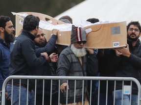 Mourners carry the body of a victim of the mosque shootings for a burial at the Memorial Park Cemetery in Christchurch, New Zealand, Friday, March 22, 2019. People across New Zealand will listen to the Muslim call to prayer on Friday as the nation marks one week since a gunman attacked two mosques and killed 50 people.
