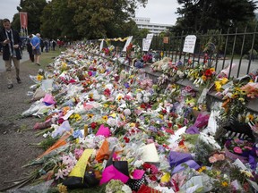 Mourners lay flowers on a wall at the Botanical Gardens in Christchurch, New Zealand, March 18, 2019.