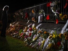 Mourners pay their respects at a makeshift memorial near the Masjid Al Noor mosque in Christchurch, New Zealand, Saturday, March 16, 2019. New Zealand's stricken residents reached out to Muslims in their neighborhoods and around the country on Saturday, in a fierce determination to show kindness to a community in pain as a 28-year-old white supremacist stood silently before a judge, accused in mass shootings at two mosques that left dozens of people dead.