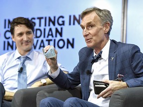 Bill Nye shows off a Canadian $5 bill, which features an astronaut and the Canadarm, during a discussion with Prime Minister Justin Trudeau at the University of Ottawa on Tuesday, March 6, 2018.