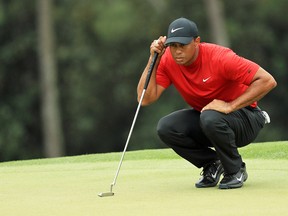 Tiger Woods of the United States lines up a critical putt on the 18th green during the final round of the Masters at Augusta National Golf Club on April 14, 2019.