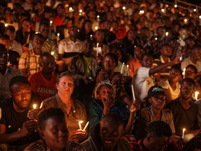Rwandans and others sitting in the stands hold candles as part of a candlelit vigil during a memorial service held at Amahoro stadium in the capital Kigali, Rwanda Sunday, April 7, 2019. Rwanda is commemorating the 25th anniversary of when the country descended into an orgy of violence in which some 800,000 Tutsis and moderate Hutus were massacred by the majority Hutu population over a 100-day period in what was the worst genocide in recent history.