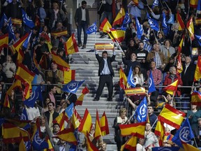 Popular Party supporters wave Spanish flags during the closing election campaign event in Madrid, Spain, Friday, April 26, 2019. Appealing to Spain's large pool of undecided voters, top candidates on both the right and left are urging Spaniards to choose wisely and keep the far-right at bay in Sunday's general election.