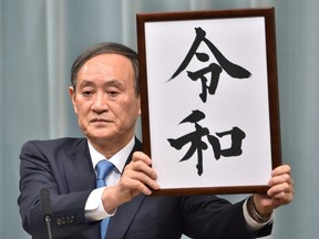 Japan's Chief Cabinet Secretary Yoshihide Suga announces the new era name "Reiwa" during a press coference at the prime minister's office in Tokyo on April 1,2019.