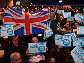 Supporters of The Brexit Party hold placards as they wait for the start of the first public rally of their European Parliament election campaign in Birmingham, central England on April 13, 2019.