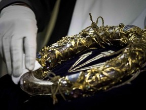 This file photo taken on April 14, 2017 shows a priest wiping the Crown of Thorns, a relic of the passion of Christ, at the Notre Dame Cathedral in Paris.