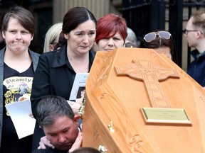 Lyra McKee's partner Sara Canning (L), reacts as pallbearers carry the coffin of journalist Lyra McKee, killed by a dissident republican paramilitary in Northern Ireland on April 18, as they leave St Anne's Cathedral in Belfast on April 24, 2019, following her funeral service.