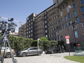 A TV camera and cars are seen outside Milan's San Raffaele hospital where former Italian Premier Silvio Berlusconi arrived, Tuesday, April 30, 2019. Berlusconi is in the hospital suffering from renal colic on the day he planned to present his candidates for European Parliament elections.