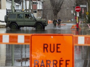 A military jeep moves through flood waters on a closed street in Gatineau, Qu., Tuesday, April 23, 2019.