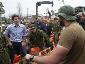 Canadian Prime Minister Justin Trudeau speaks with members of the Canadian Forces as they fill sandbags Wednesday April 24, 2019 in Gatineau, Que.