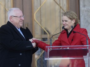 Israeli President Reuven Rivlin holds the hand of Governor General Julie Payette as she speaks about the relations between Canada and Israel during a welcome ceremony at Rideau Hall in Ottawa, Monday, April 1, 2019.