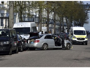 A view of the scene near the Ukrainian Embassy after police fired shots after an incident, in Holland Park, London, Saturday April 13, 2019.  British police say shots were fired outside the Ukraine Embassy in London Saturday morning after a car rammed into parked cars in front of the building. London's Metropolitan Police said firearms and stun guns were used to stop and detain a suspect who drove a vehicle at the police car when police arrived on the scene.