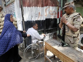 Army officers secure a polling station as people enter to vote on constitutional amendments on the second day of a nationwide referendum in Cairo, Egypt, Sunday April 21, 2019. Egyptians are voting on constitutional amendments that would allow el-Sissi to stay in power until 2030.