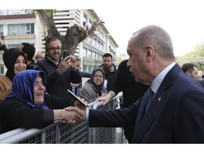 Turkey's President Recep Tayyip Erdogan shakes hands with a supporter as he arrives to speak at an assembly for religious schools, in Istanbul, Saturday, April 13, 2019. Erdogan's ruling party still appealing the results of the local elections in Istanbul, where the opposition has a razor-thin lead and Erdogan said Wednesday election results in Istanbul should be canceled over irregularities.(Presidential Press Service via AP, Pool)