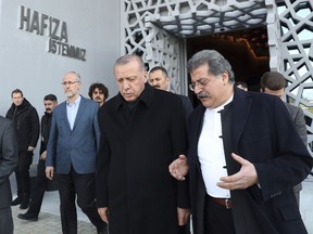 Turkey's President Recep Tayyip Erdogan, center, in a first public appearance after Sunday elections in Istanbul, Thursday, April 4, 2019, listens as he visits an uncompleted museum dedicated to the July 15, 2015 coup attempt. Erdogan's ruling party is appealing the results of the local elections in Istanbul, where the opposition has a razor-thin lead. (Presidential Press Service via AP, Pool)